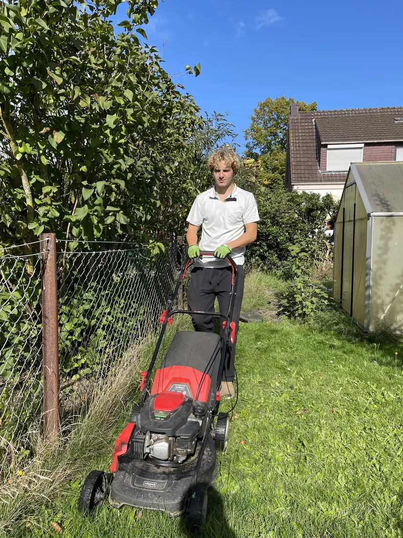 Henri beim Rasenmähen in einem Kundengarten